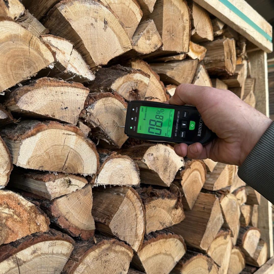 Moisture meter reading 8.8% on a stack of Northwest Firewood Company's kiln-dried logs